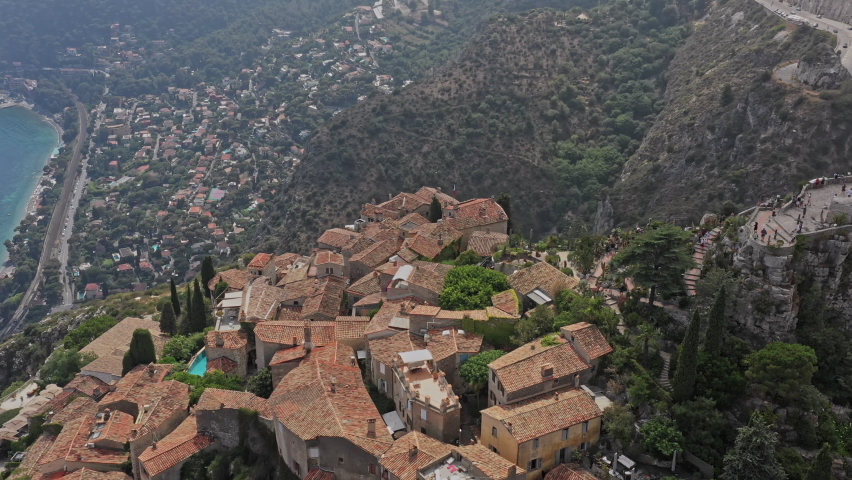 Eze France Aerial v22 low level birds eye view, drone flyover cliffside housing and hilltop exotic botanical garden and fort ruins toward beautiful mediterranean seascape - July 2021 | Shutterstock HD Video #1082389084