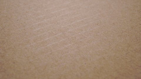 Recycled kraft cardboard box background. Macro. Slow rotation. Wrapping paper