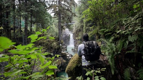 Male Hiker Walks In The Forest With Scenic View Of Mamquam Falls In Squamish, BC, Canada. wide