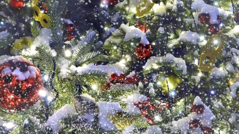 Christmas tree is decorated with toys and garlands outdoors under the falling and swirling snow. New year colorful background. Animated 4K video.