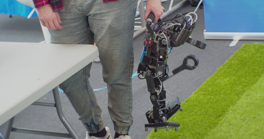 unrecognizable man holding a broken robot in his hand.