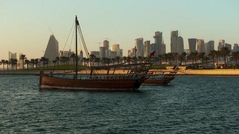 Doha, Qatar- November 11 2021: Doha skyline afternoon  shot showing Dhows with Qatar flags in the Arabic gulf in foreground and Doha skyline in background