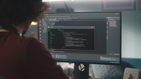 Anonymous man using computer to create software while working on outsource project at home