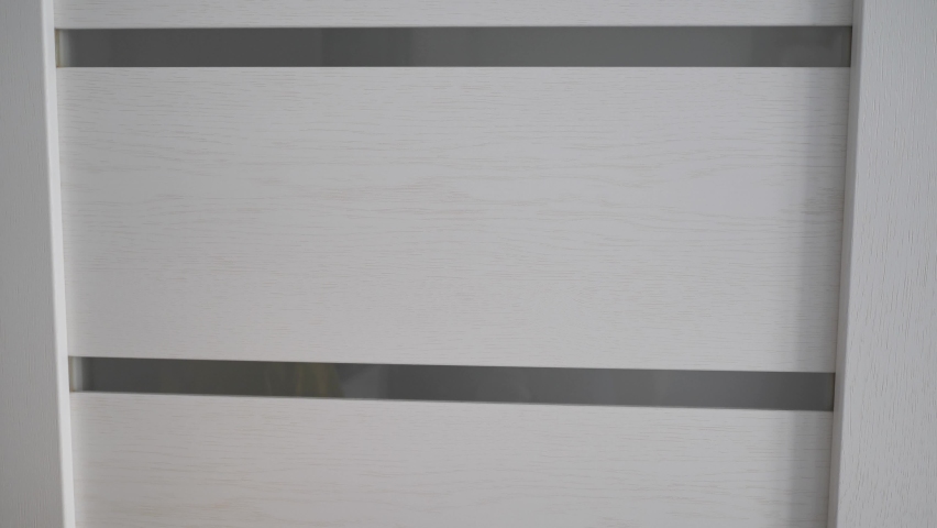 Closeup womans hands stick pink sticker paper sheets on white wooden door. Concept home working quarantine. Video 4k footage