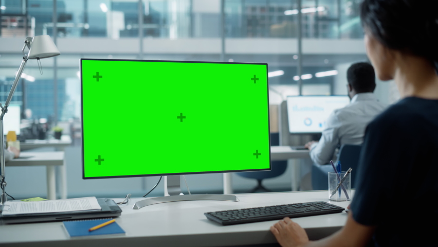 Close Up Over the Shoulder Shot of a Businesswoman Working on Desktop Computer with Chroma Key Green Screen Mock Up Display. Digital Projects Manager Typing Data, Using Keyboard and Mouse. Royalty-Free Stock Footage #1082416573
