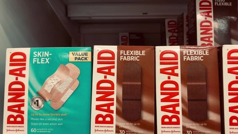 Edmonton, Canada - November 9, 2021: Boxes of Band-Aid flexible fabric for dark-skin, Black and Brown people on display on a pharmacy shelf