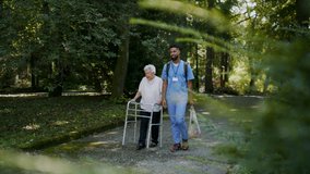 Senior woman and caregiver outdoors on a walk with walker in park, talking. - Powered by Shutterstock - Get 15% off with code: PIKWIZARD15