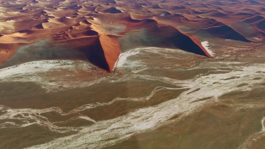 Aerial view of Sossusvlei sometimes written Sossus Vlei is a salt and clay pan surrounded by crips red dunes located in the southern part of the Namib Desert 4k high quality resolution animation Royalty-Free Stock Footage #1082423269