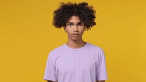 Smiling good kind surprised happy young curly african american man 20s years old wears white t-shirt ask who me oh it so sweet put hands on chest isolated on plain yellow background studio portrait