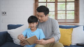 Family concept of 4k Resolution. father teaching children to read books at home. Parents tutoring son to do homework. - Powered by Shutterstock - Get 15% off with code: PIKWIZARD15