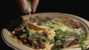 This close up video shows a platter full of carne asada street tacos.