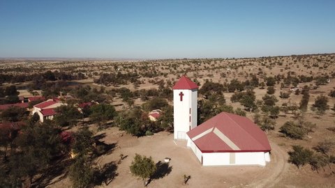 Khomas Hochland, Namibia, 07.03.20: 4K aerial drone video of Africa savanna hills and plains, tiny settlement Baumgartsbrunn and small white stone church west of Windhoek, southern Africa