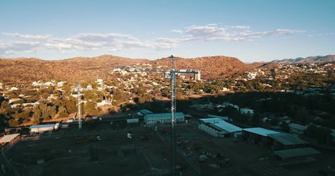 Windhoek, Khomas Region, Namibia, 12.01.20: 4K summer afternoon aerial editorial footage of large construction site with tall cranes in Windhoek, the capital of Namibia, southern Africa