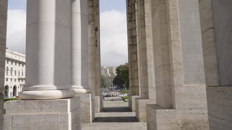 Massive white columns in downtown of Genoa, camera tilting up view