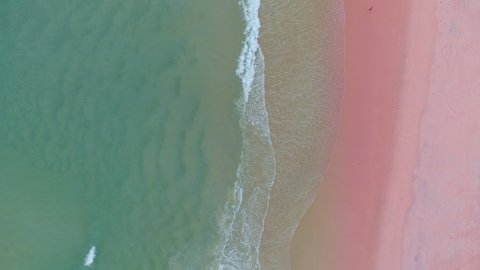 Amazing aerial view of sea and pink sand beach at sunset Beautiful sand beach with ocean wave foams crashing on sandy shore at Phuket island paradise Thailand Travel and tour background
