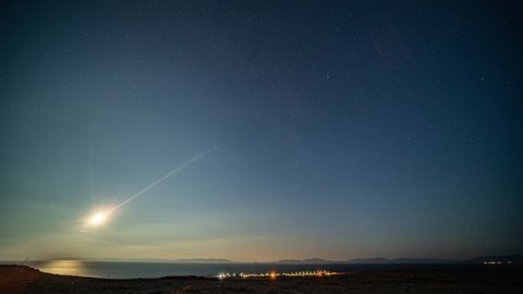 Full night timelapse. Moon passing over the night sky. Bright splashes of the northern lights.