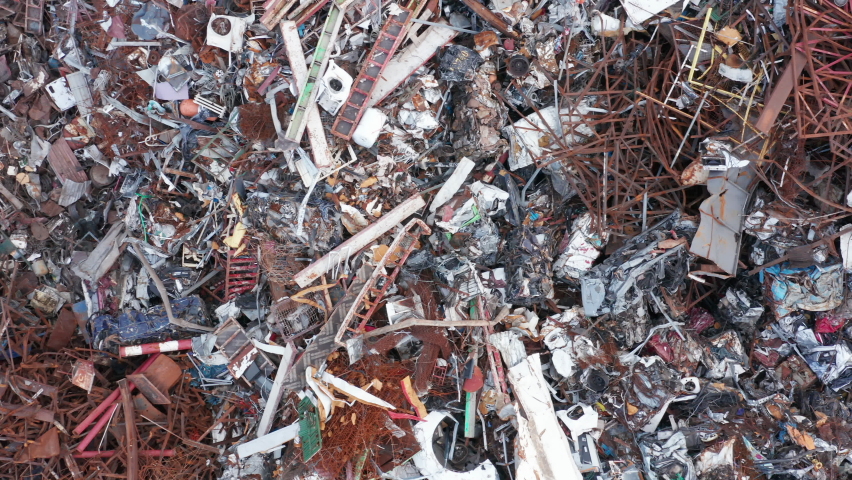 Scrap metal at a junkyard (wrecking yard) ready to be recycled. Industrial facility for collecting and recycling steel junk, garbage and trash. Pollution prevention and environmental protection issues Royalty-Free Stock Footage #1082470066