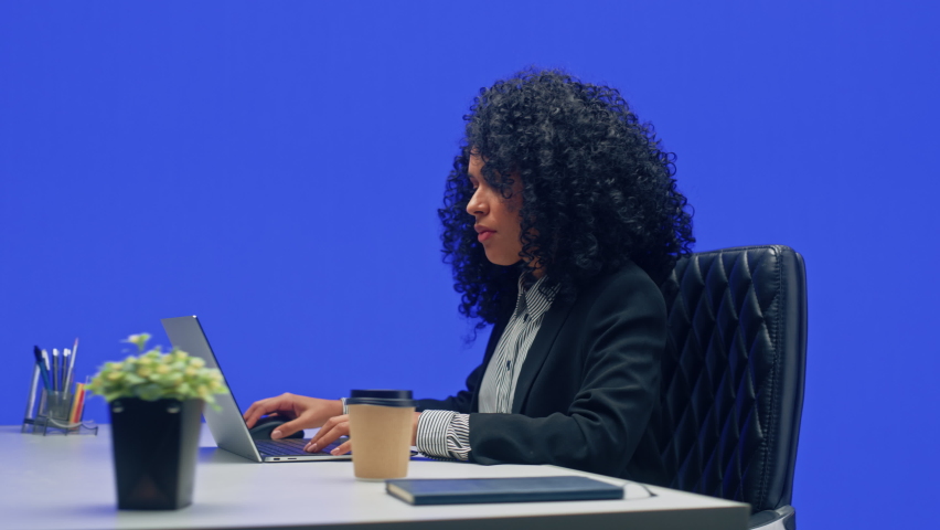 Green Screen Office Background: Black Businesswoman Sitting at Her Desk Working on a Laptop Computer. African American Woman working with Big Data e-Commerce. 360 Degree Tracking Shot. Moving Around Royalty-Free Stock Footage #1082482042