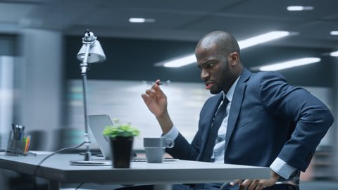 360 Degree Time-Lapse Office: Productive Black Businessman Sitting at His Desk Working on a Computer. African American Entrepreneur Wearing Suit working with Investment. Moving Around Tracking Shot
