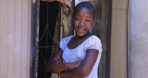 Poverty. Inequality. Portrait. Cute young Black African girl smiling and looking at camera