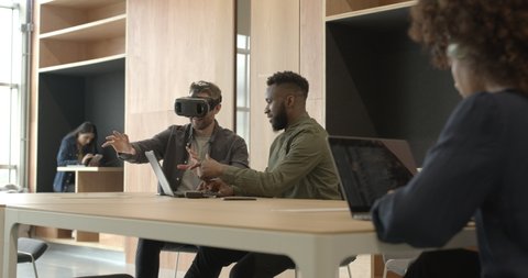 Engineers working with virtual reality headset in creative office