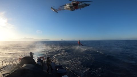 ALICANTE, SPAIN – OCTOBER 9, 2021. Rescue training with an helicopter and a coast guard of the Spanish Customs in the coast of Alicante, Spain..

