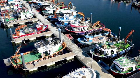 PONTEVEDRA, SPAIN – JUNE 29, 2021. Aerial view of fishing boats dedicated to the collection of mussels, moored in the port of Arosa Island, Spain.