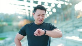 Sport asian man looking smart watch at modern track. Man runner using smartwatch bracelet. Portrait fitness man checking result. Male in sportswear jogging in the street urban background city stadium - Powered by Shutterstock - Get 15% off with code: PIKWIZARD15
