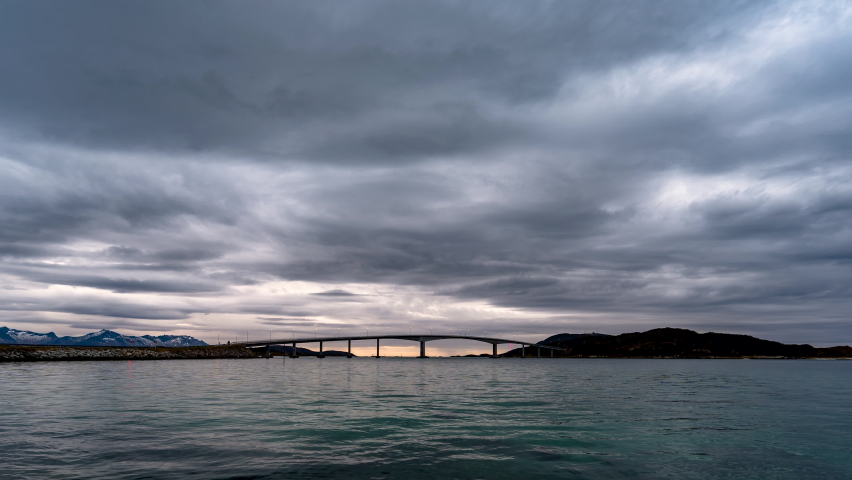 Dramatic clouds as traffic flows over Summer Island bridge; day to night time lapse