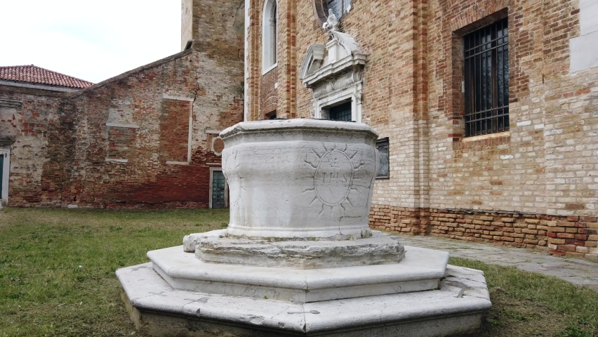 Europe, Italy , Venice -  white marble ancient historic water well in the courtyard of a church on the island of Murano