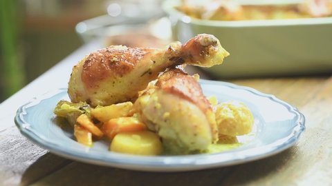Serving of roasted chicken drumsticks with potatoes and curry.