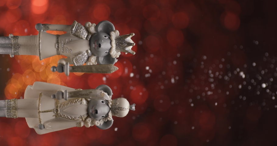Christmas figurine illustrating two white knights holding swords while snow is falling down in front of bokeh red background