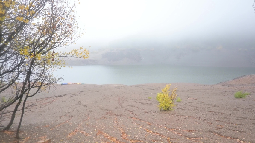 Man observing the mysterious lake on a cloudy and foggy day