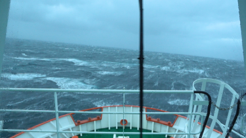 Ship in storm. A lot of splashes. View from bridge. Ship climb up wave. Strong pitching. High waves hit ship. White foam on water. Very strong storm. Bow breaks waves | Shutterstock HD Video #1082505883