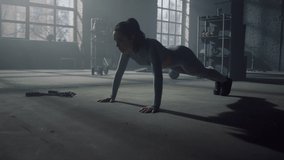Active female athlete push ups exercise in dark gym. Athletic woman fitness training in loft building. Fit girl hands muscle strength workout in sport club. Strong body bodybuilder silhouette practice - Powered by Shutterstock - Get 15% off with code: PIKWIZARD15