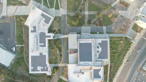 Solar panels on roof of modern school college building. Generating clean renewable electric energy. Drone aerial shot 4k. Solar power on sunny day.  