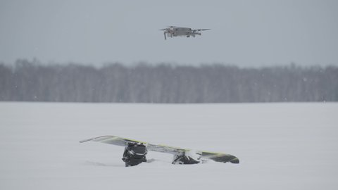 Search drone detects missing person snowboarder covered in snow, rescue operations.