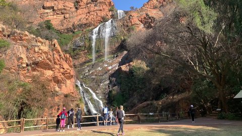 Krugersdorp, South Africa - 22nd June 2021: Water fall at National Botanical Garden with tourist observing.