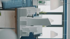 Vertical video: Empty architectural office with building model and blueprints plans on table. Nobody in space used for real estate design and development with architecture construction structure.