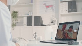 Asian veterinarian girl talk to pet owner on online virtual video call. Professional vet doctor woman use laptop computer to give treatment plan consult for little cat animal while sit in pet hospital