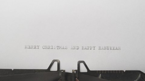 Typing MERRY CHRISTMAS AND HAPPY HANNUKAH at the typewriter