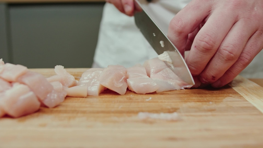 Close up of a chef's hands slicing chicken breasts on the cutting board. Professional cooking. Recipe step by step Royalty-Free Stock Footage #1082531386