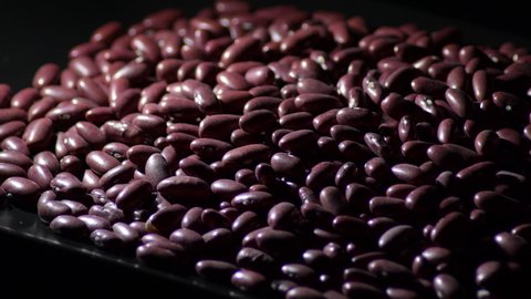 Red beans in a black tray, rotation
