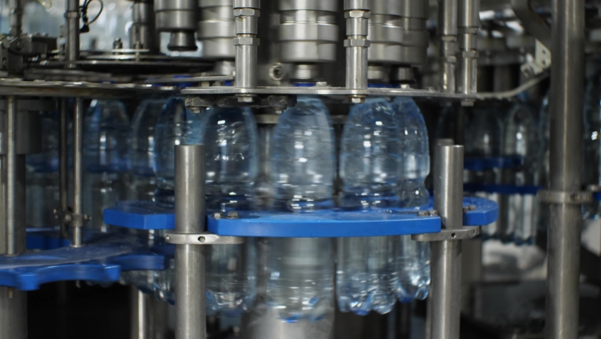 The work of the plastic bottle capping machine at the plant for the production of mineral water and soft drinks | Shutterstock HD Video #1082536741