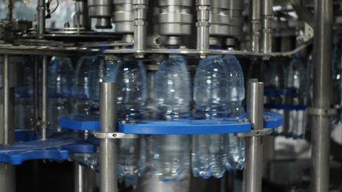 The work of the plastic bottle capping machine at the plant for the production of mineral water and soft drinks
