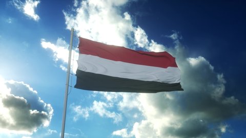 Flag of Yemen waving at wind against beautiful blue sky