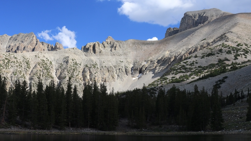 Clouds slowly pass in a blue sky behind Wheeler Peak in Great Basin National Park, Nevada. Seen from Stella Lake.