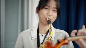 Close-up saxophone,Asian woman who is a member of a classical band is practicing in a recording studio to prepare for a concert.