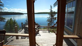 Stepping out onto the deck of a lake front cabin in the sunny, warm, summer weather.