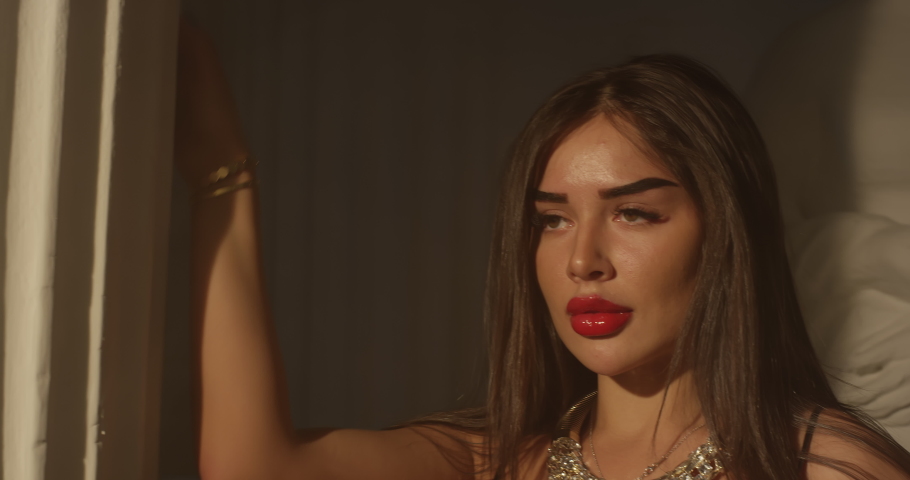 Sexy young girl with jewelry in an evening black dress. Languid sexy look close-up of a beautiful figure of a brunette model